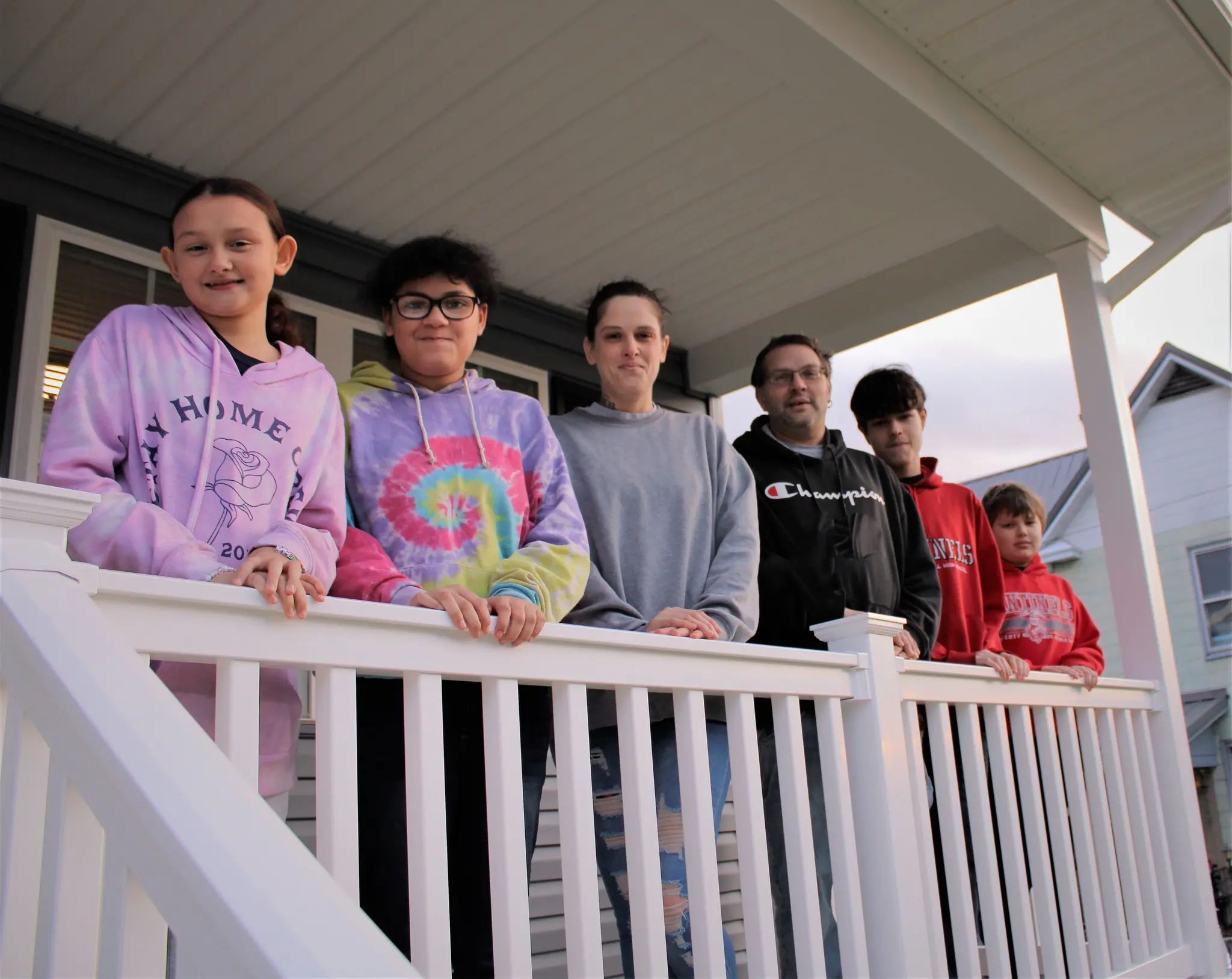 A Family of 6 people in front of Habitat home